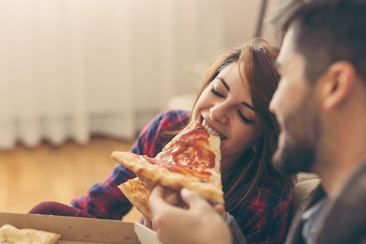 Guy and girl eat pizza
