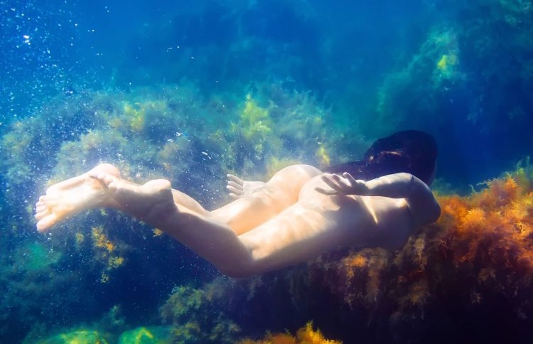 Naked mermaids under water