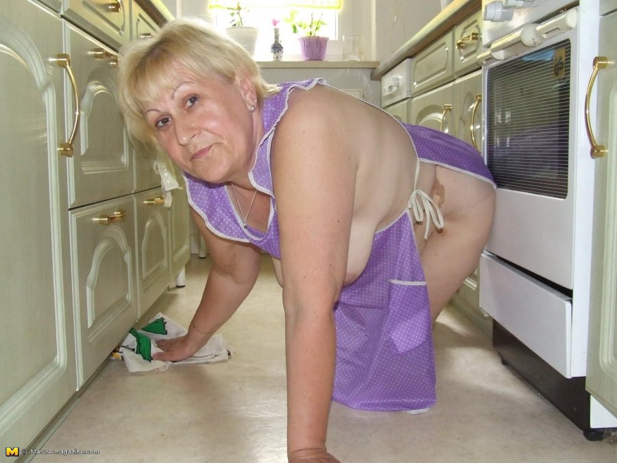 Mature woman cleaning the house naked